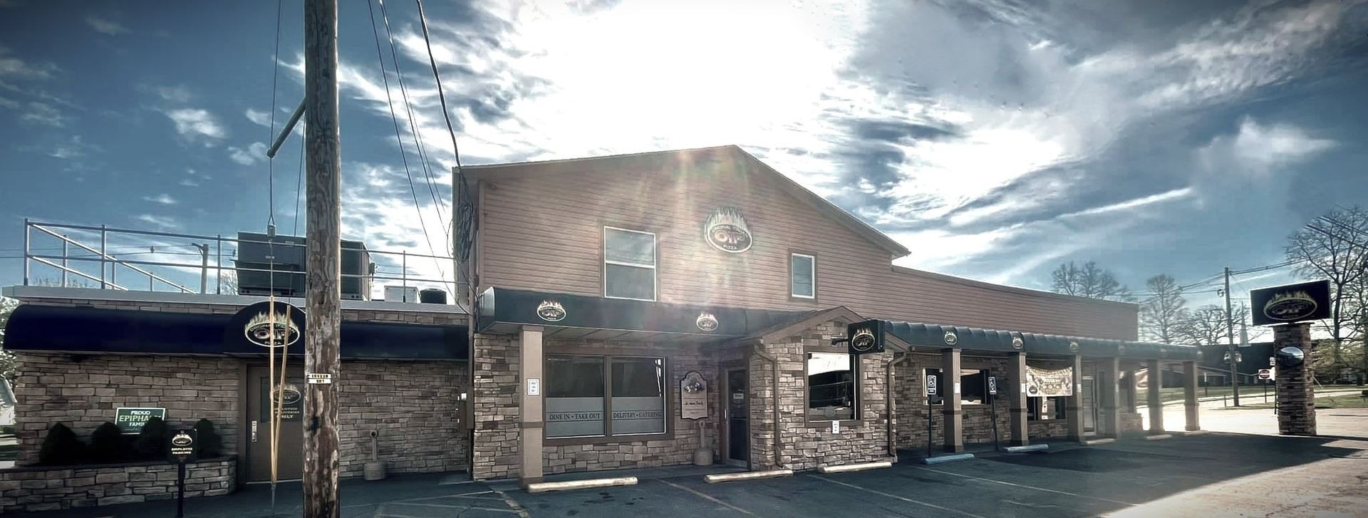 Picture of Original Italian Pizza building with sun setting behind it